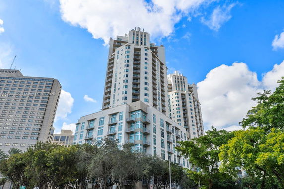 Front view of a modern high-rise building with multiple balconies and large windows.