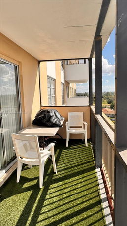 Balcony view with outdoor seating and railing.