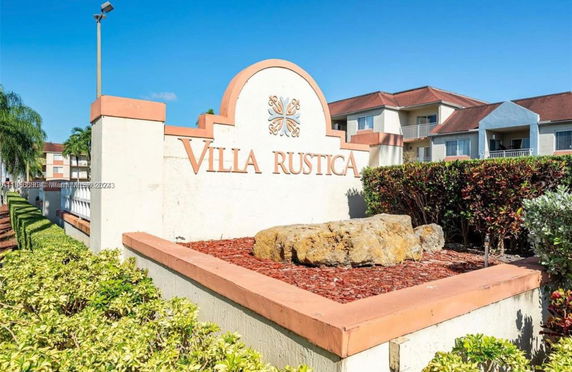 Front view of a two-story apartment building with a decorative sign.