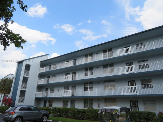 Front view of a multi-story residential building with balconies.