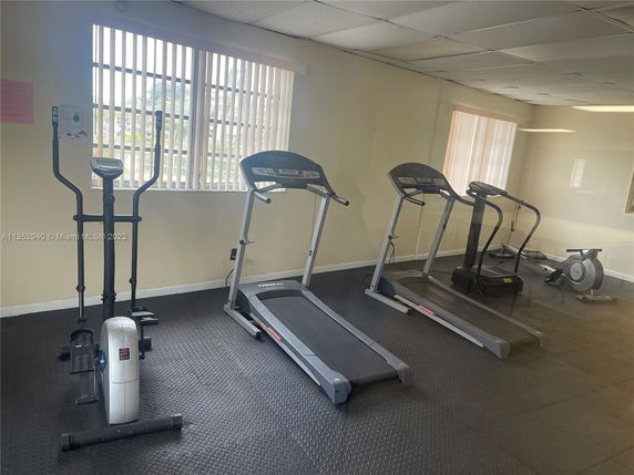 Indoor gym area with exercise equipment including treadmills and an elliptical machine.