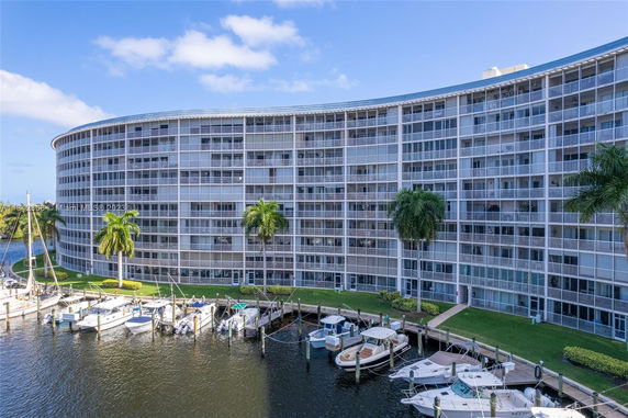 Front view of a mid-rise apartment building with a curved facade and balconies.