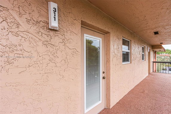 Front view of a building with a textured wall and door labeled 311.