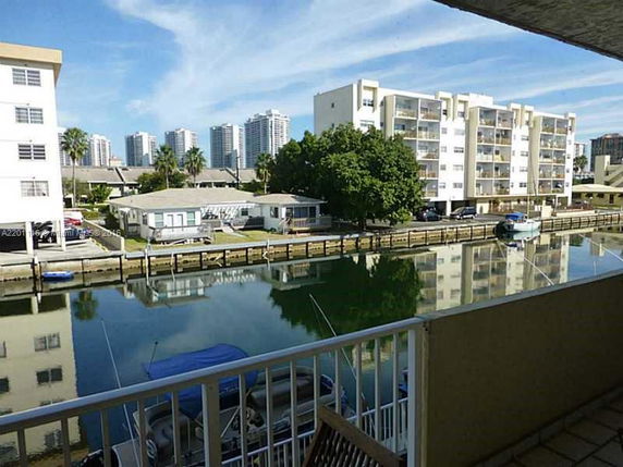 View from a building showing a canal lined with residential buildings and high-rise structures in the background.