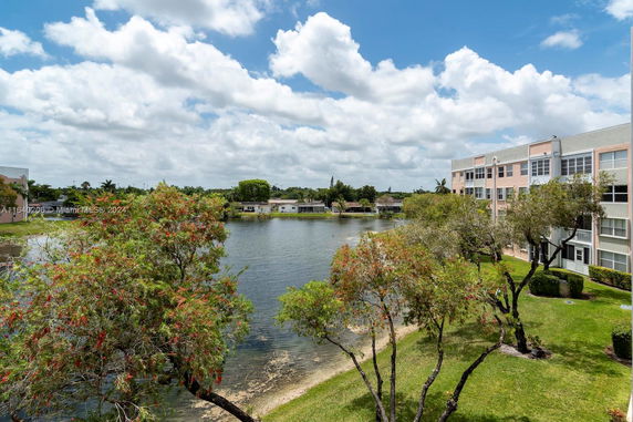 View of a lake with surrounding trees and buildings.