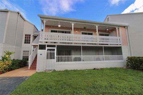 Front view of a two-story house with a balcony and decorative railing.