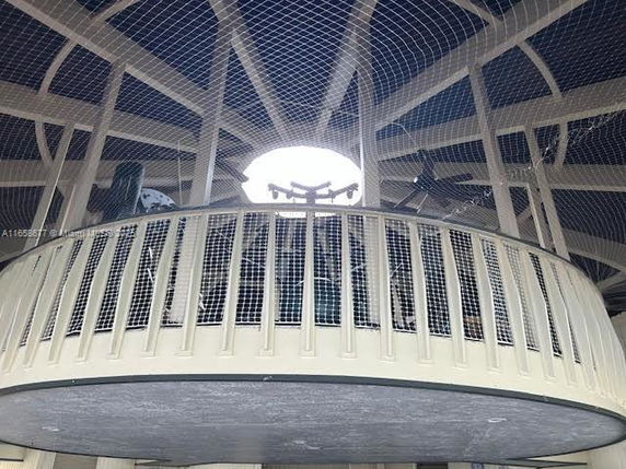 View of an indoor play area with a netted circular platform and railings.