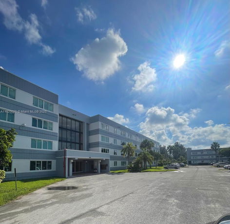 Front view of a multi-story building under a clear blue sky.