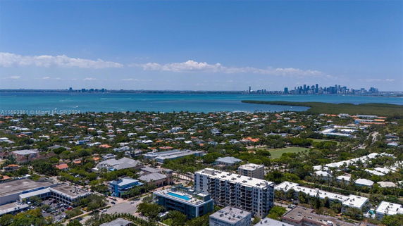 Aerial view of a cityscape with residential buildings and a large body of water in the background.