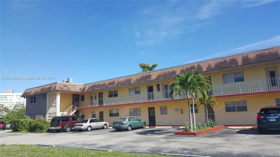 Front view of a two-story apartment building with parking area.