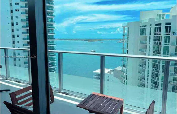 View from a balcony showing surrounding high-rise buildings and a body of water.