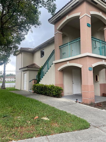 Front view of a two-story house with a staircase and balcony.