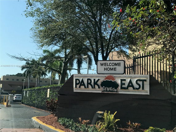 Entrance view of Park East signage with surrounding trees and a gate.