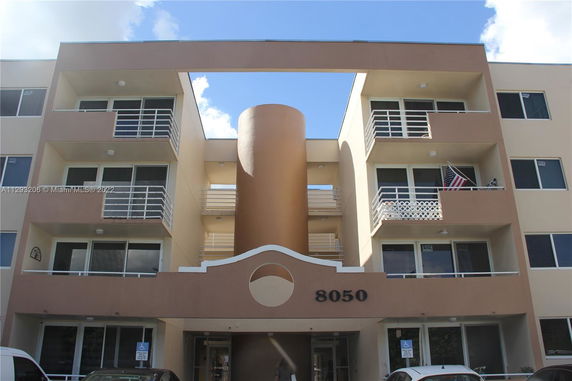 Front view of a multi-story building with balconies and a unique architectural design.