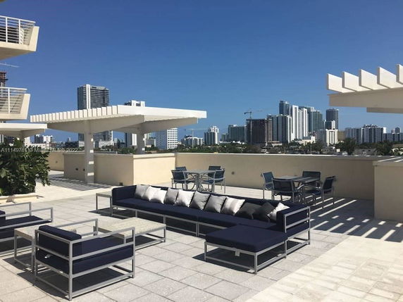 Rooftop with modern outdoor seating and city skyline in the background.