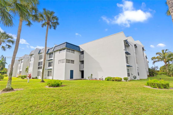 Front view of a multi-story residential building with a white exterior.