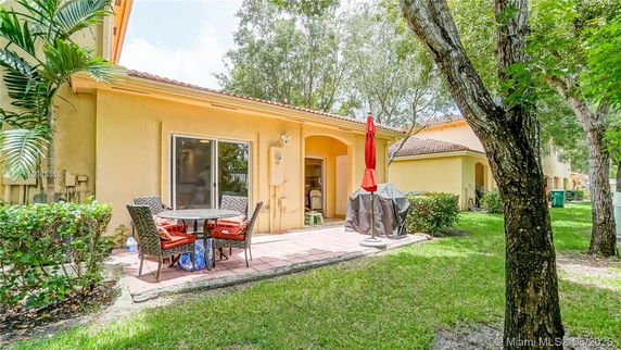 Rear view of a single-story house with patio and outdoor furniture