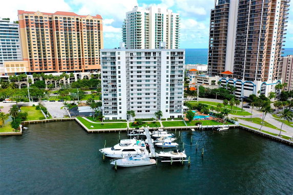 View of a waterfront high-rise building with a marina.