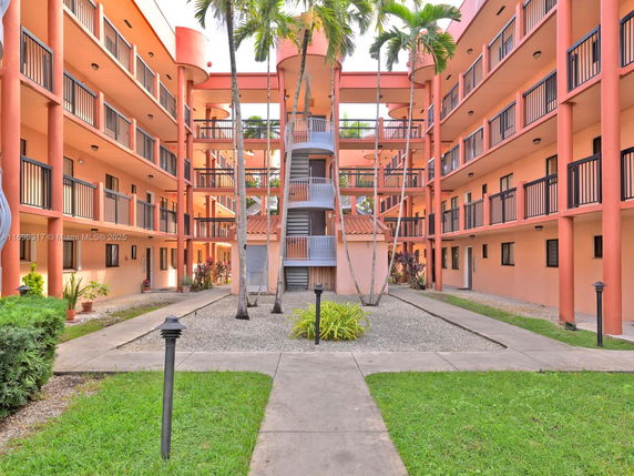 Courtyard view of a multi-story building with exterior walkways and central staircase.