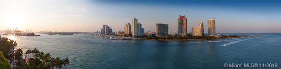 Panoramic view of waterfront high-rise buildings with surrounding water and cityscape.