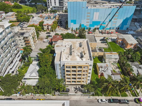 Aerial view of a building with a flat rooftop featuring multiple air conditioning units.