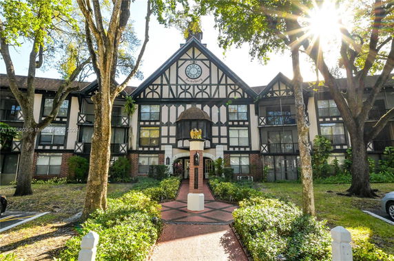 Front view of a multi-story building with decorative half-timbering and a central gable.