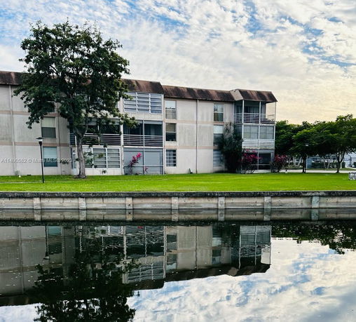 Front view of a multi-story residential building near a canal.
