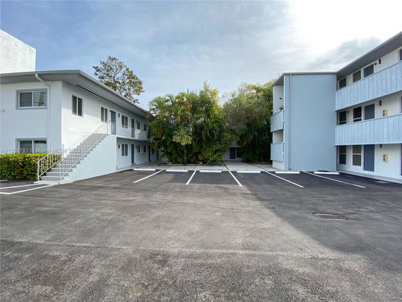 Outdoor parking area in front of a two-story apartment building