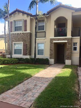 Front view of a two-story house with stone and stucco exterior and a covered entrance.