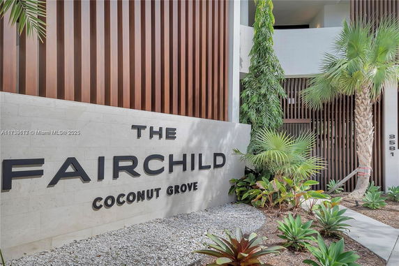 Front view of a modern building with wooden paneling and large sign reading 'The Fairchild Coconut Grove'.