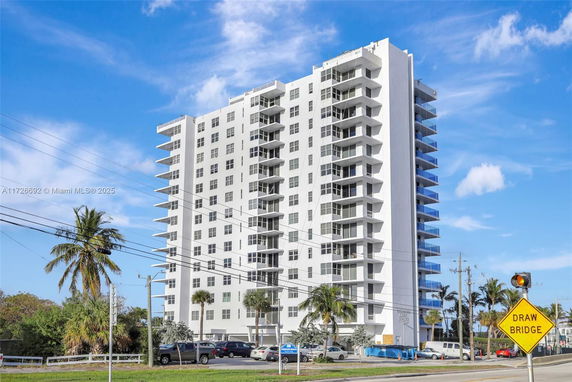 Front view of a high-rise apartment building with balconies on each floor.