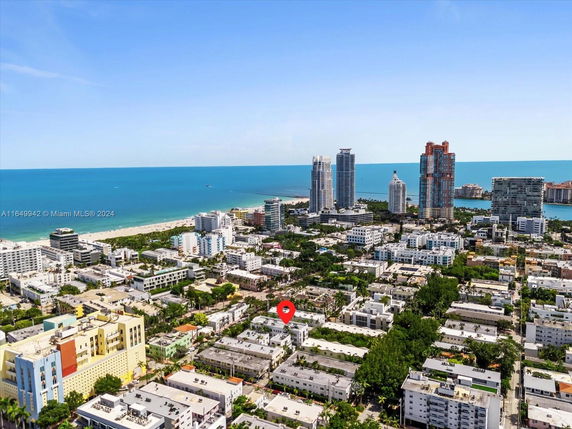 Aerial view of a coastal cityscape with high-rise buildings and a beach in the background.