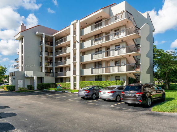 Front view of a multi-story apartment building with balconies.