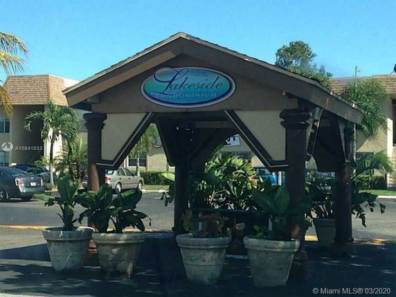 Front view of a condominium entrance structure with a sign reading 'Lakeside Condominium'.