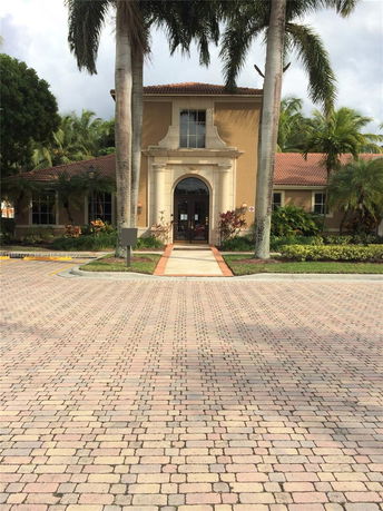 Front view of a building with an arched entrance and tiled roof.