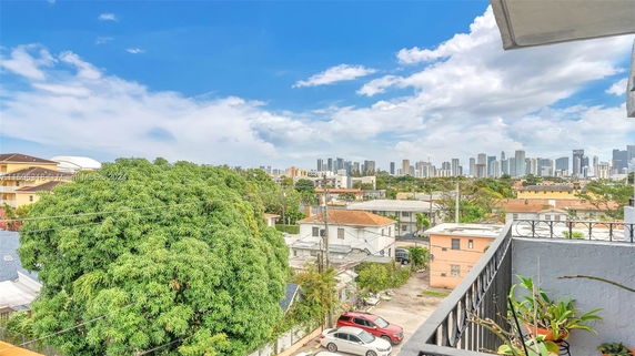View of city skyline and residential neighborhood from a balcony.