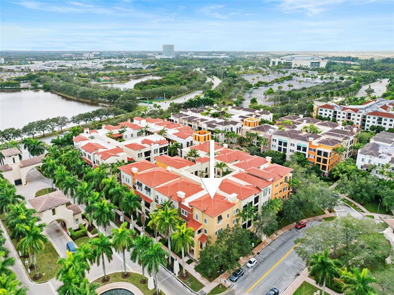 Panoramic view of a residential complex with red-tiled roofs and surrounding landscape.