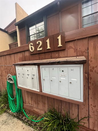 Front view of a building section with mailbox installation and visible address number 6211.