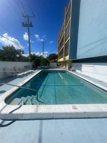 Outdoor swimming pool adjacent to a multi-story building.