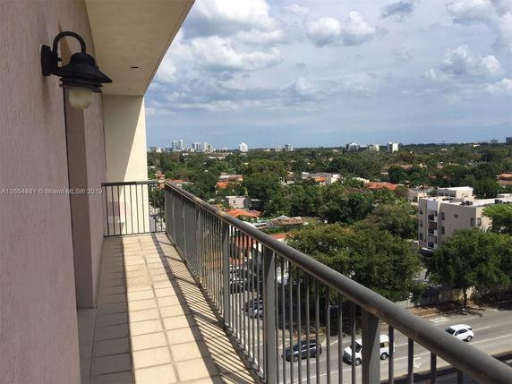 Balcony view overlooking a cityscape with buildings and trees.