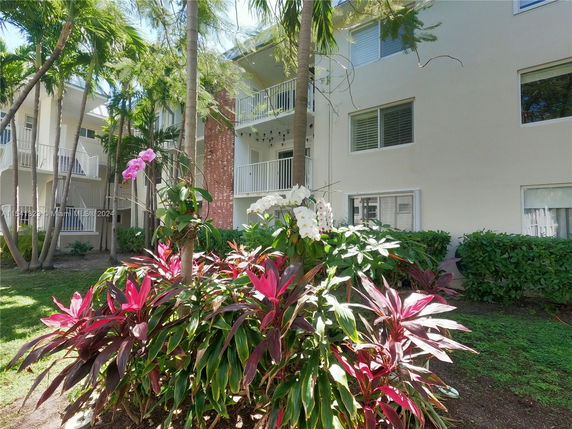 Front view of a multi-story building with balconies and large windows.