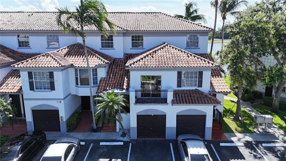 Front view of a multi-story house with a tiled roof and garages.