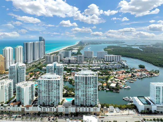 Panoramic view of a coastal cityscape with high-rise buildings and a coastline.
