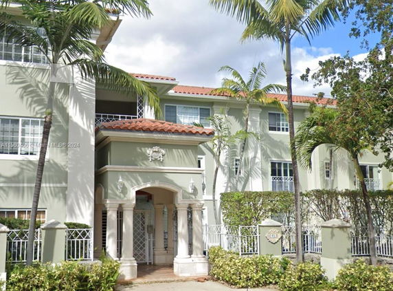 Front view of a multi-story building with columns and decorative elements.