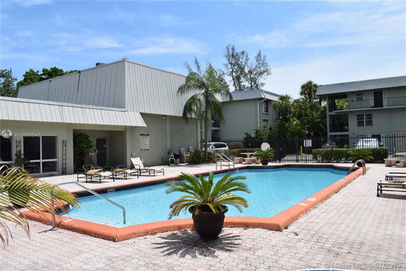 Outdoor view of a swimming pool area with nearby building structures.
