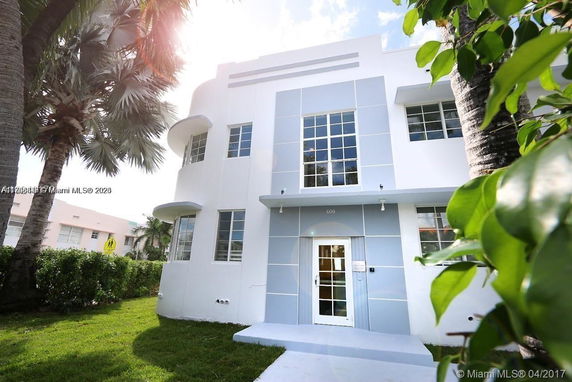 Front view of a modern two-story building with large grid windows and a white and blue facade.