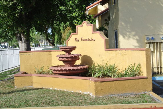 Front view of a building with a decorative fountain and a sign reading 'The Fountains'.