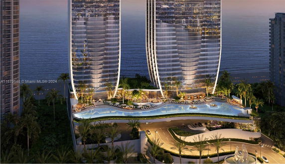 Front view of modern high-rise twin towers with curved architecture overlooking the ocean.