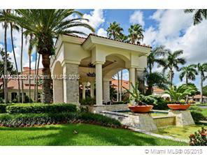 Front view of a luxury building with arched entrance and landscaped surroundings.