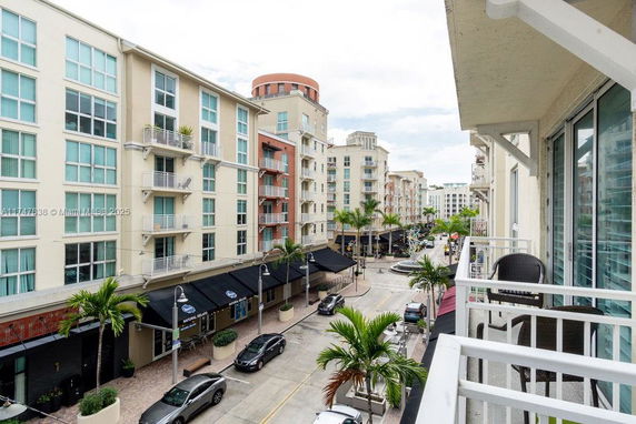 Urban street view from a building balcony with multiple residential complexes.